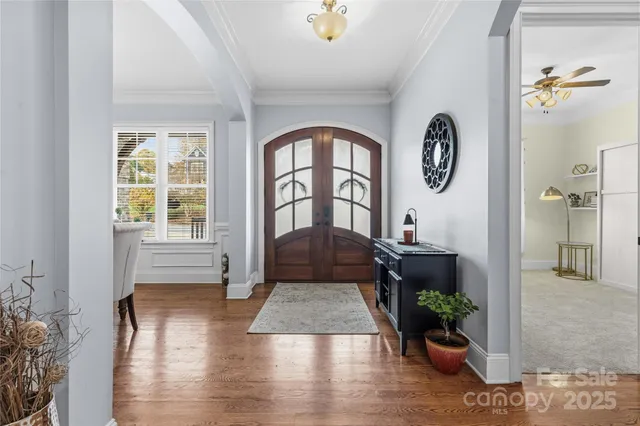 a living room with furniture chandelier and large windows