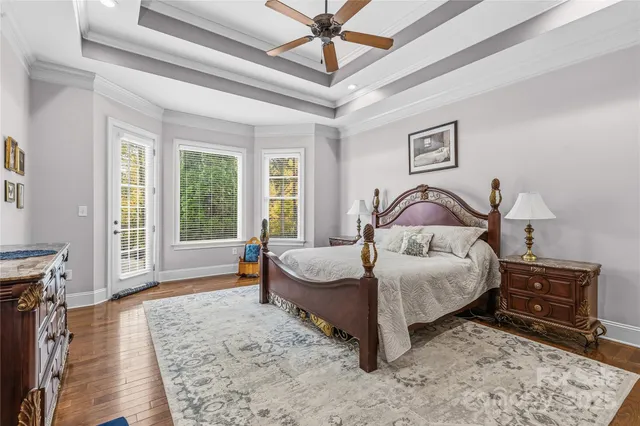 a bedroom with a bed a dresser and wooden floor