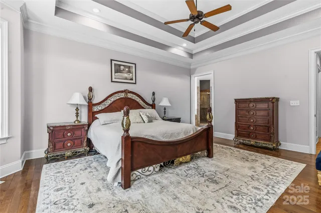 a bedroom with a bed a chandelier and dresser