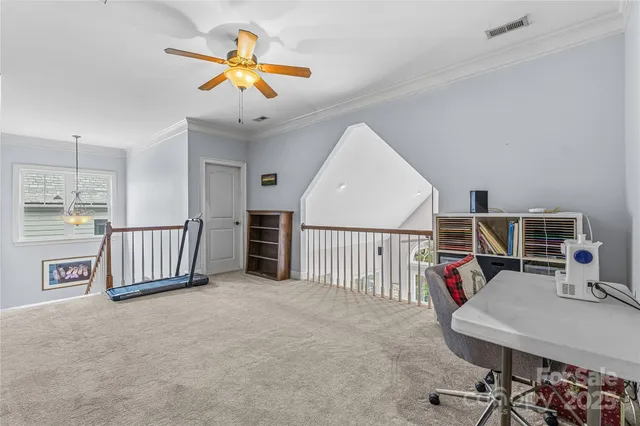 a view of a workspace with furniture and a ceiling fan