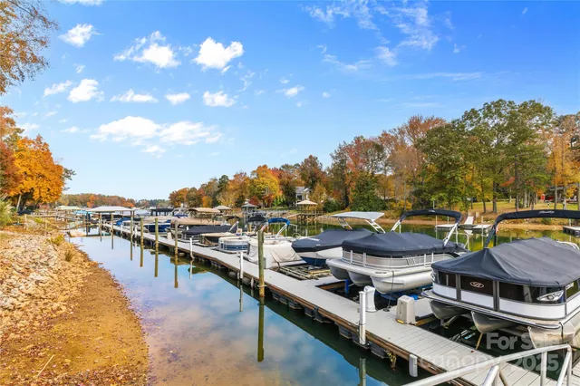 a roof deck with table and chairs with wooden floor