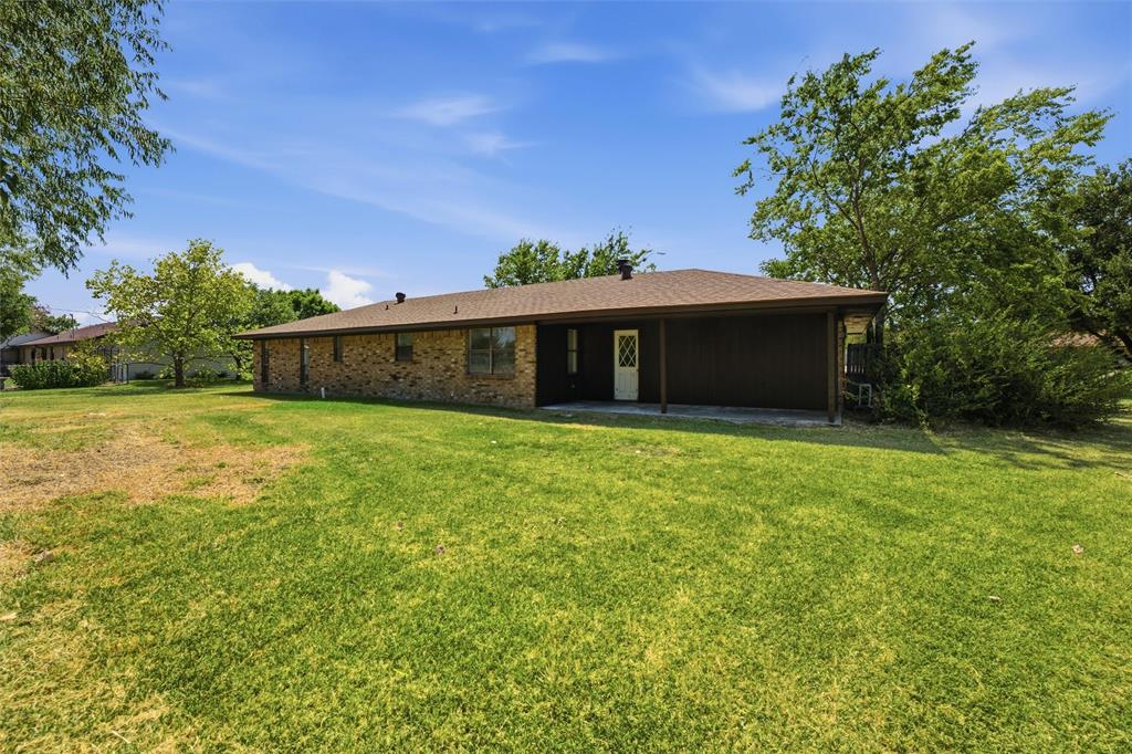 124 Prairie Creek Road Red Oak, TX 75154 - Photo 17 of 17 Expansive backyard featuring a manicured lawn, mature trees, and a covered patio