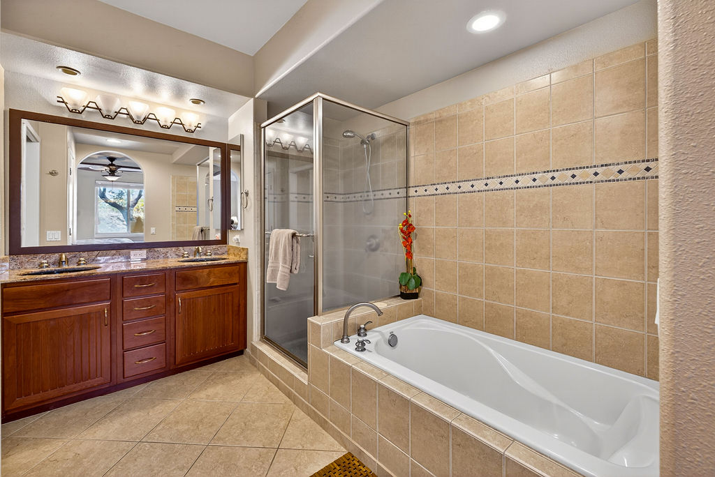 68-1122 Na Ala Hele Road, Unit H2 Kamuela, HI 96743 - Photo 6 of 12 a bathroom with a granite countertop tub a sink and a large mirror