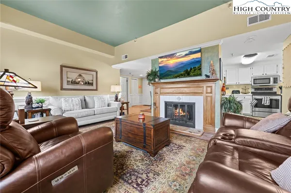 a living room with furniture a flat screen tv and a fireplace