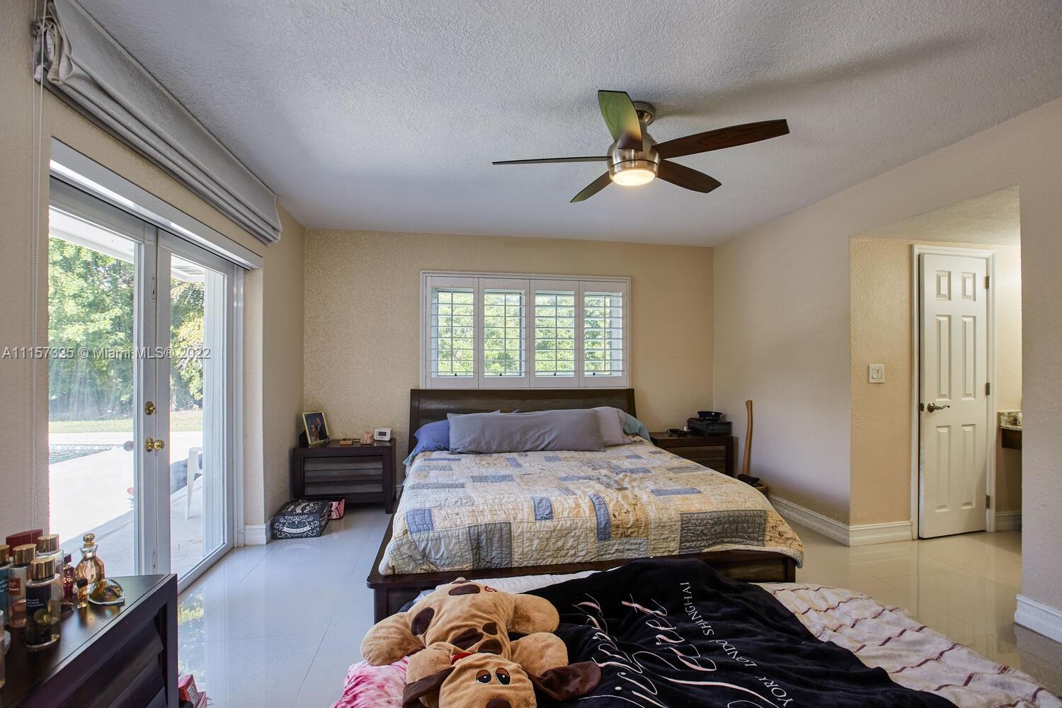 11103 Southwest 124th Road Miami, FL 33176 - Photo 11 of 23 a bedroom with a bed and a chandelier