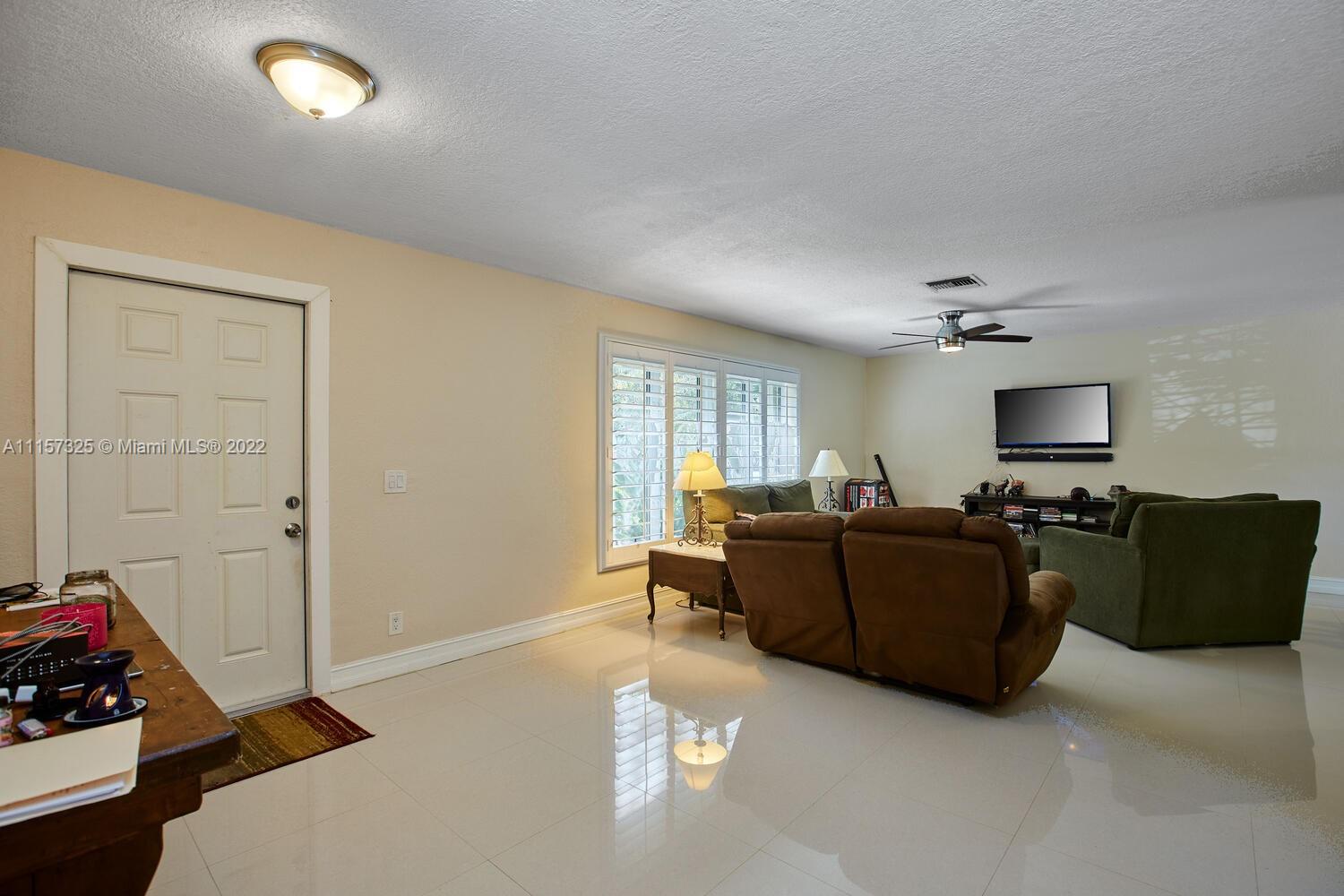 11103 Southwest 124th Road Miami, FL 33176 - Photo 3 of 23 a living room with furniture and a flat screen tv