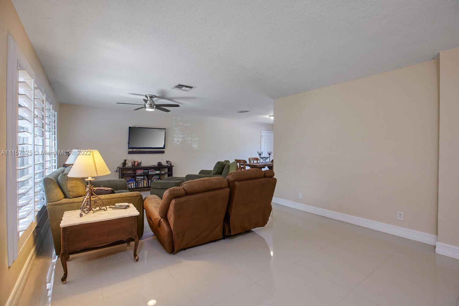 11103 Southwest 124th Road Miami, FL 33176 - Photo 4 of 23 a living room with furniture and a chandelier