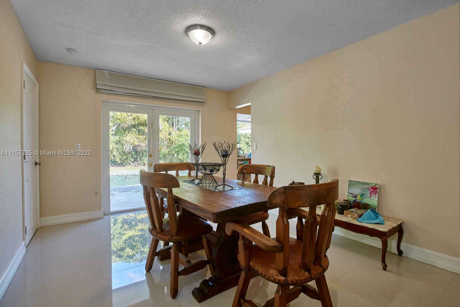 11103 Southwest 124th Road Miami, FL 33176 - Photo 6 of 23 a view of a dining room with furniture and a window