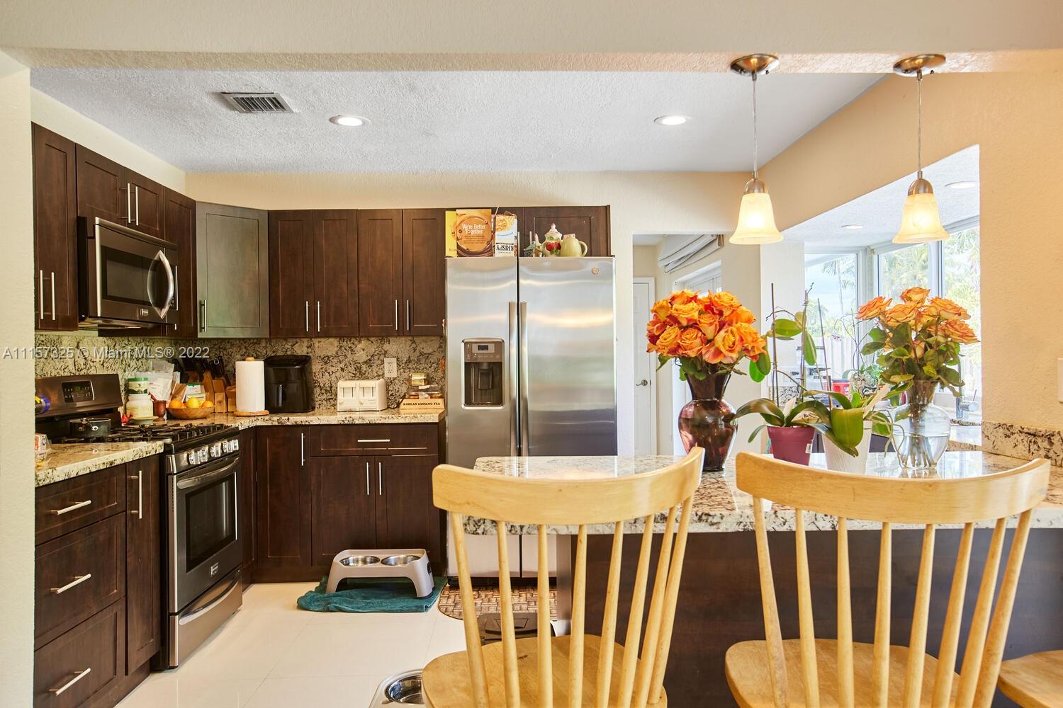 11103 Southwest 124th Road Miami, FL 33176 - Photo 9 of 23 a kitchen with stainless steel appliances kitchen island granite countertop a table and chairs