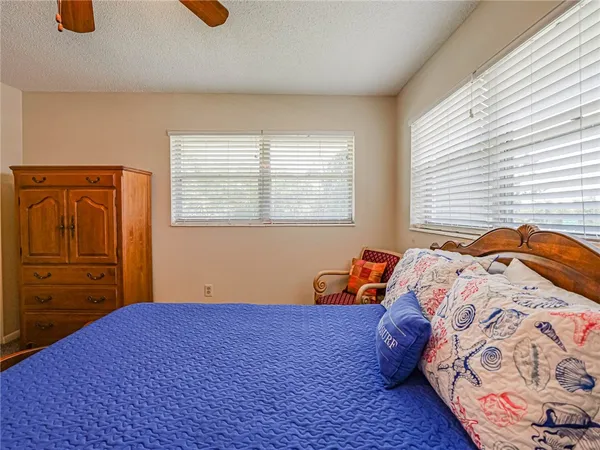 a bedroom with a bed and dresser with wooden floor