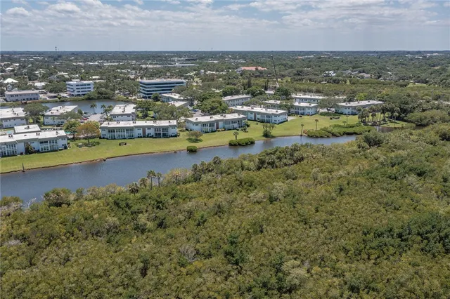 an aerial view of residential houses with outdoor space and lake view