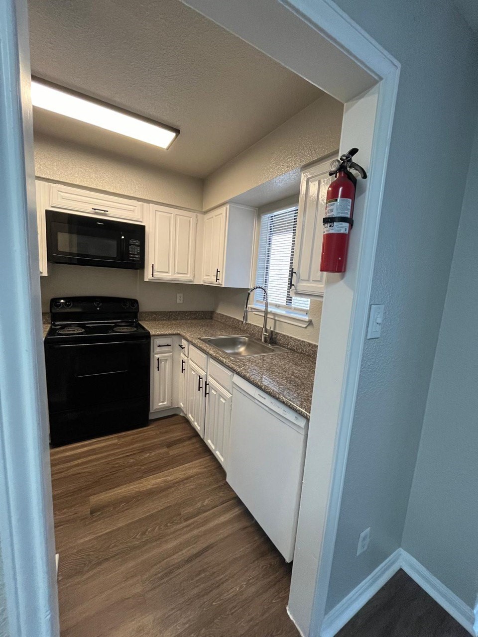 9255 West Sam Houston Parkway South, Unit 105 Houston, TX 77036 - Photo 6 of 13 a kitchen with granite countertop a refrigerator stove and microwave