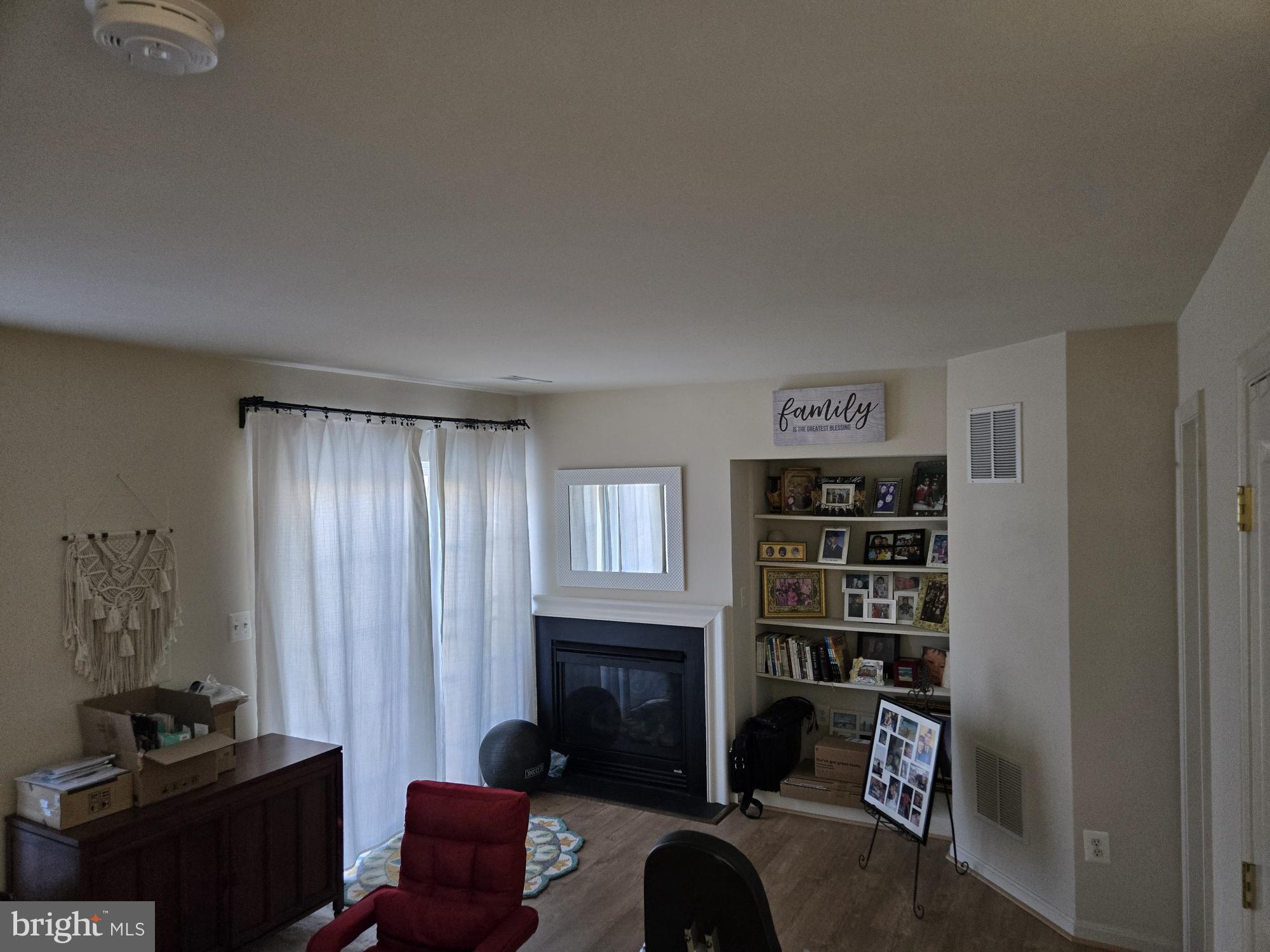 9254 Cascade Falls Drive Bristow, VA 20136 - Photo 13 of 14 a living room with furniture a fireplace and a book shelf