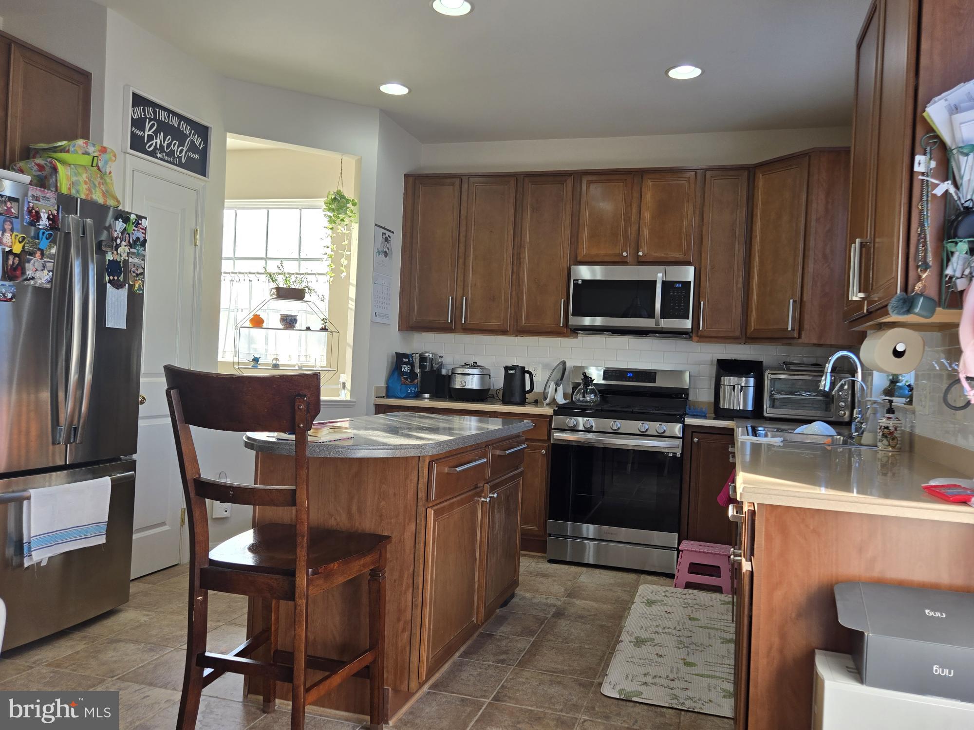 9254 Cascade Falls Drive Bristow, VA 20136 - Photo 10 of 14 a kitchen with a stove a sink a microwave a dining table and chairs