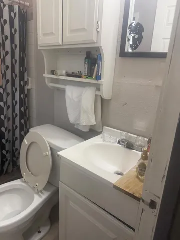 a bathroom with a sink toilet and a mirror