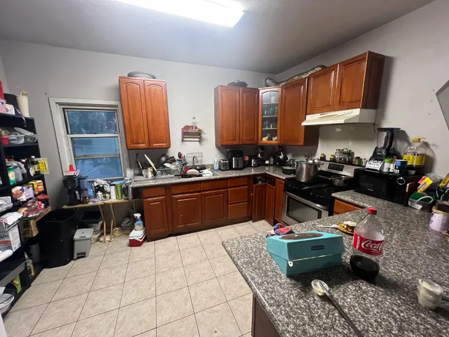 a kitchen filled with a white stove top oven and cabinets