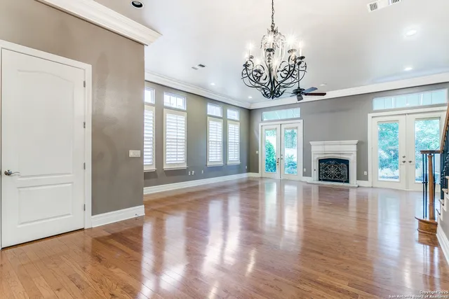a view of a livingroom with wooden floor fireplace and windows