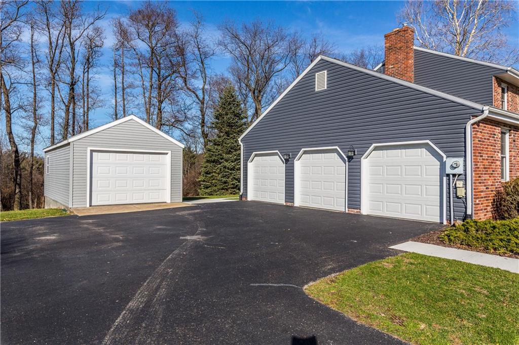 Pull into your mostly level Asphalt driveway to your 3 car Attached Garage and yes another Detached Garage that can store your boat ! . Easy entry to house with no steps into Kitchen after your shopping trips..