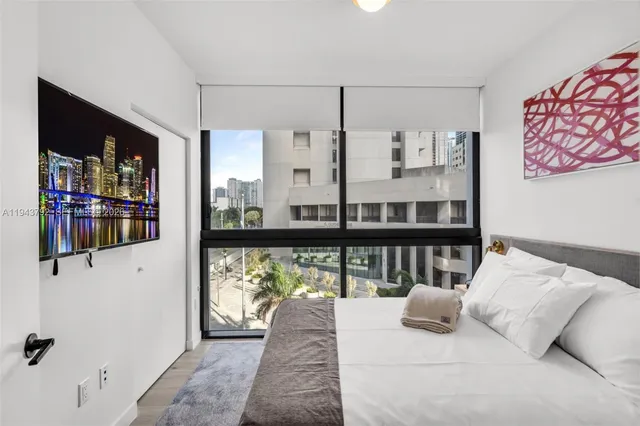 a view of a bedroom with furniture and window