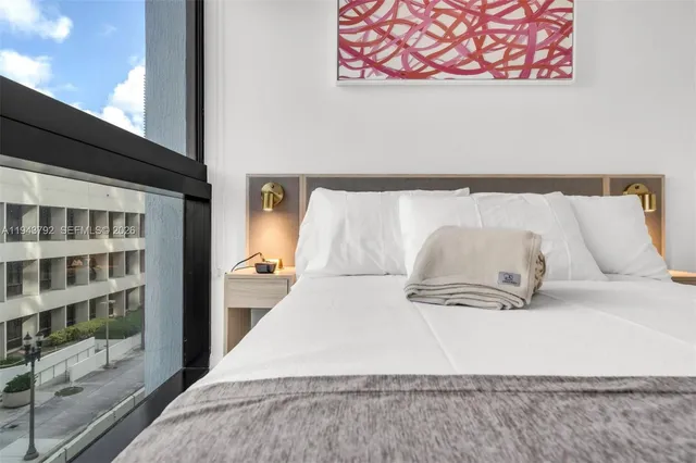 a view of a bedroom with a bed and wooden floor