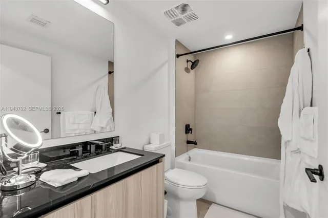 a bathroom with a granite countertop sink toilet and shower