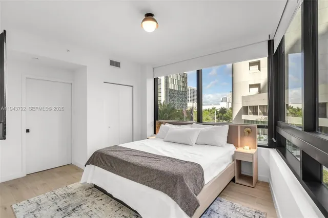 a bedroom with a large bed and a large window