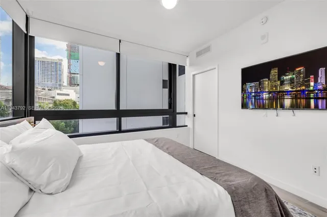 a bedroom with a large bed and a flat tv screen