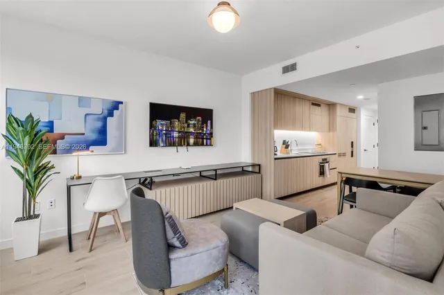 a living room with furniture and kitchen view