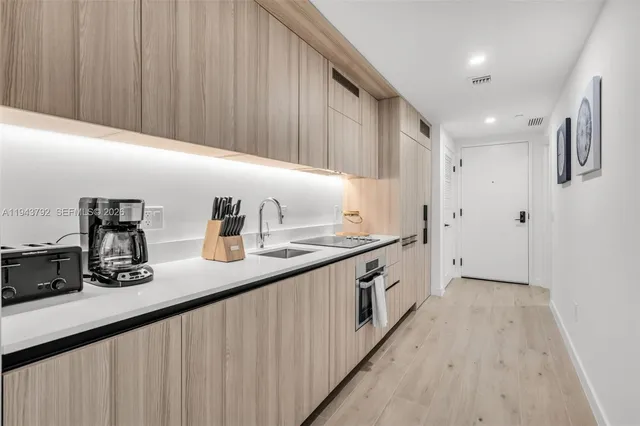 a kitchen with sink a refrigerator and cabinets