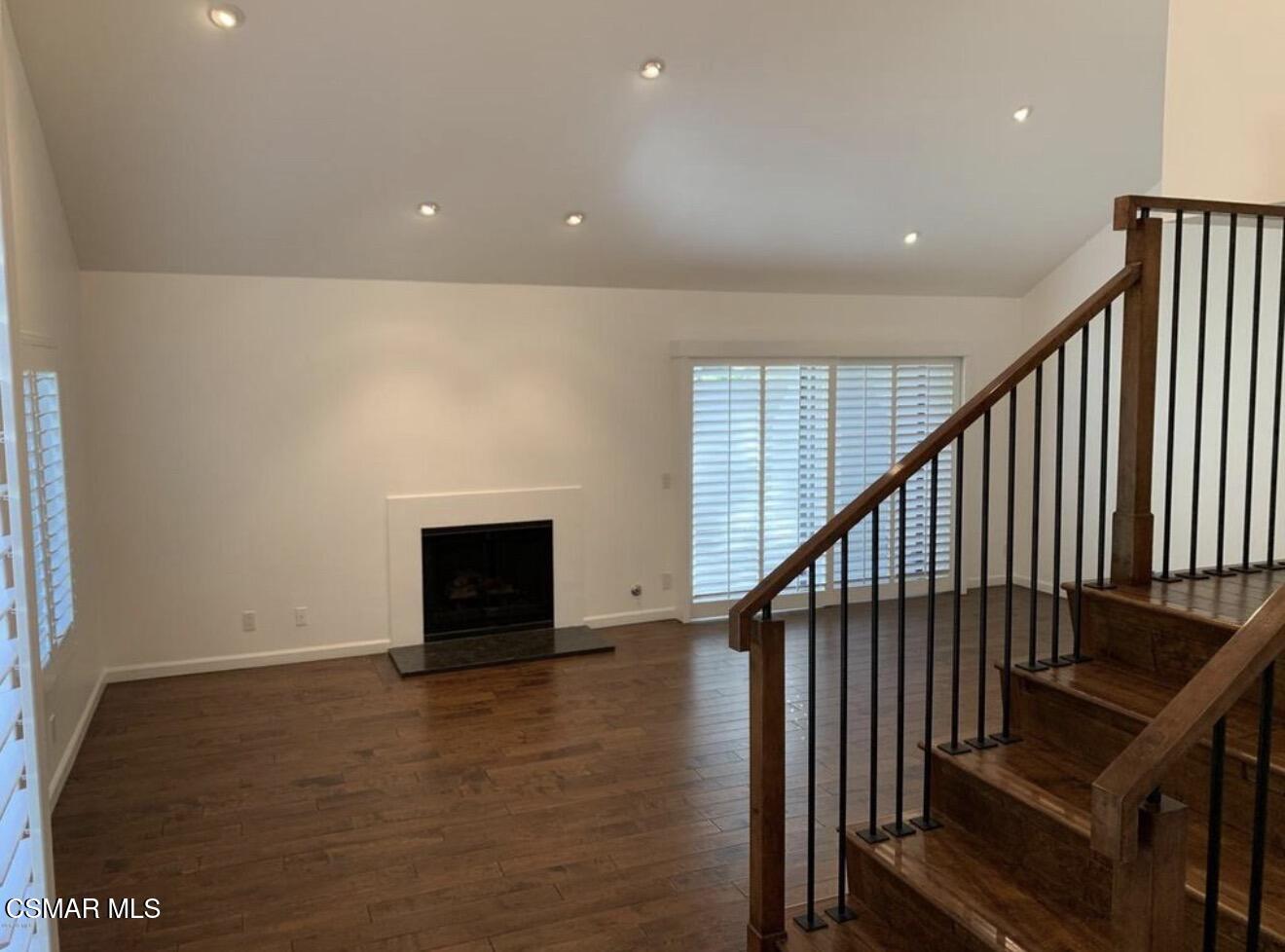 924 Thistlegate Road Oak Park, CA 91377 - Photo 3 of 20 an entryway in a hall with wooden floor and a fireplace