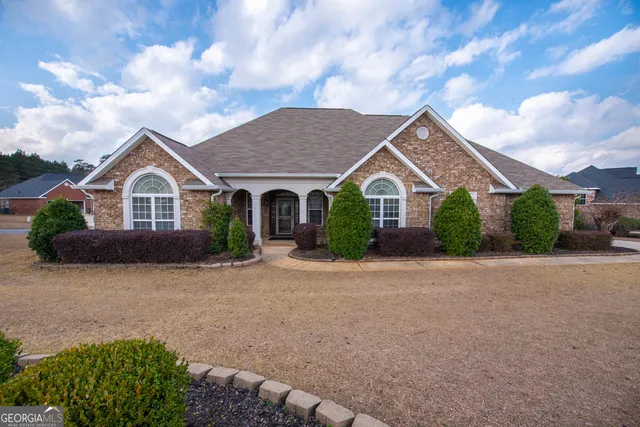 a view of a house with a yard and fence