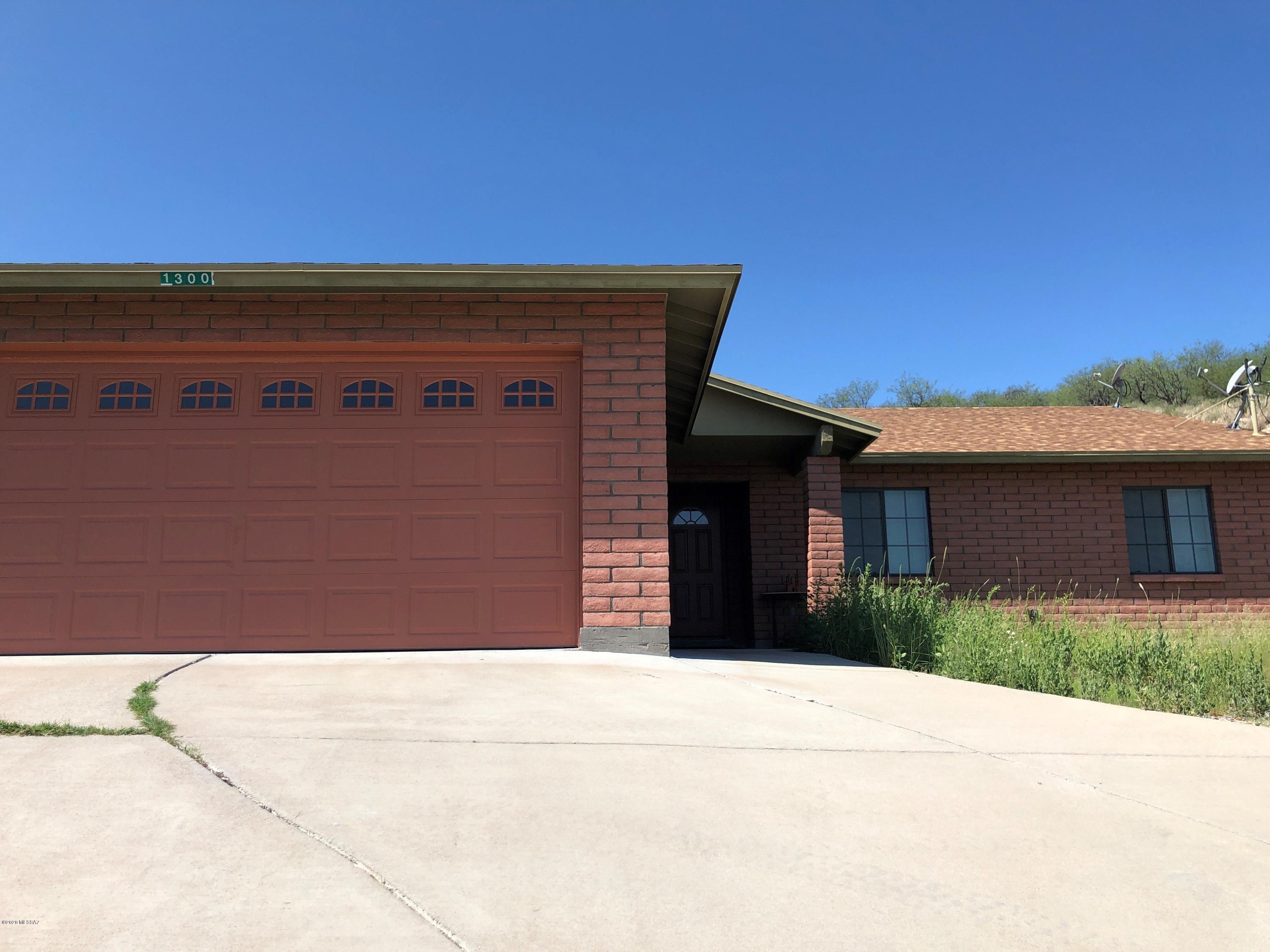 1300 Calle Cherokee Rio Rico, AZ 85648 - Photo 1 of 6 a view of a stone house with a small yard