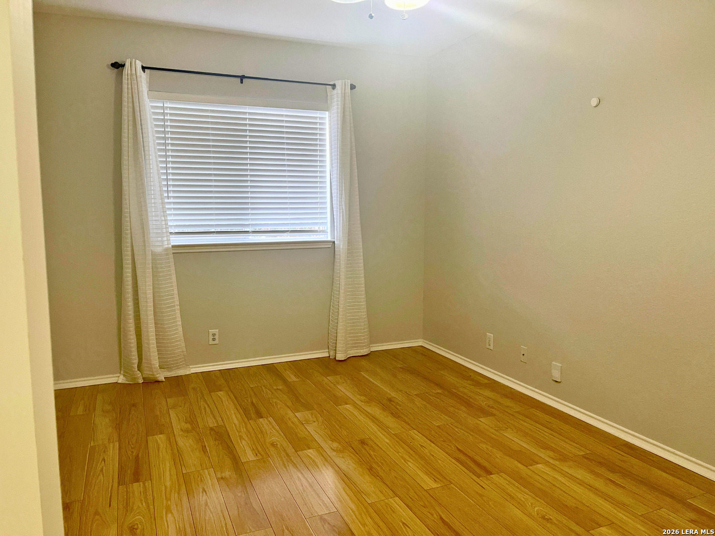 324 Willow Loop Cibolo, TX 78108 - Photo 7 of 20 a view of an empty room with wooden floor and a window
