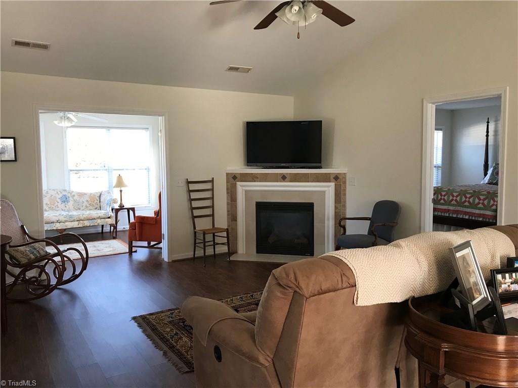115 Brae Ridge Lane King, NC 27021 - Photo 2 of 14 Laminate wood floor in living room. Gas log fireplace. Cathedral ceiling.