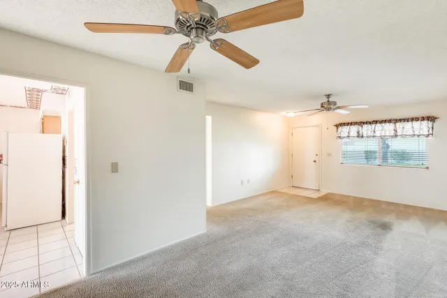 an empty room with closet and a ceiling fan