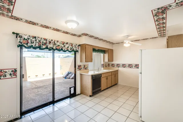 a view of a kitchen with a sink and refrigerator