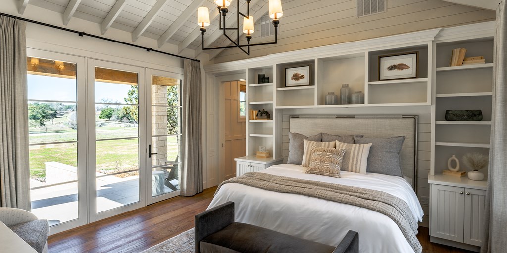 811 Boot Ranch Circle Fredericksburg, TX 78624 - Photo 20 of 34 a bedroom with a large bed and a large window