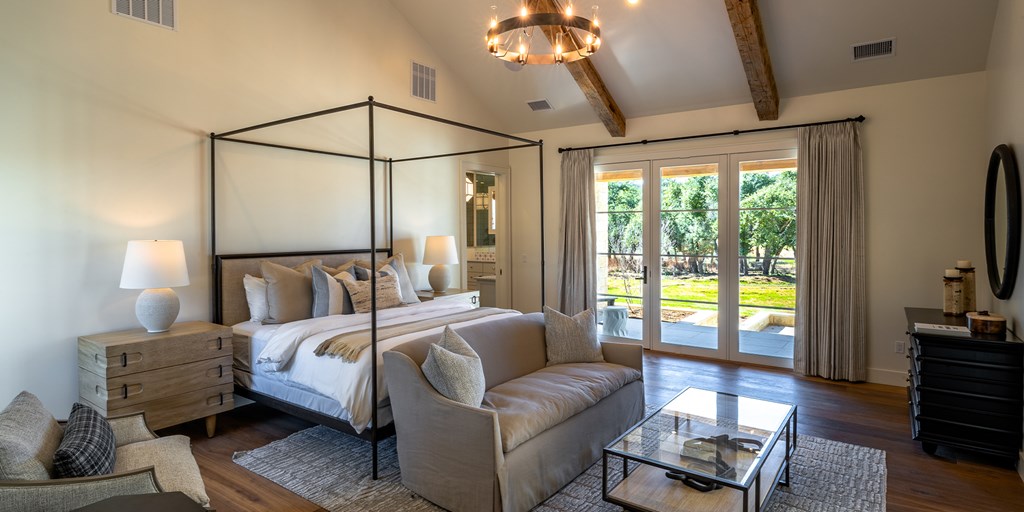 811 Boot Ranch Circle Fredericksburg, TX 78624 - Photo 25 of 34 a bedroom with a bed couch and a flat tv screen on the dresser