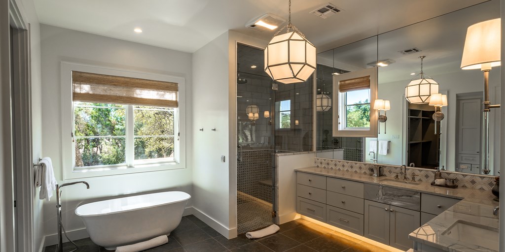 811 Boot Ranch Circle Fredericksburg, TX 78624 - Photo 28 of 34 a spacious bathroom with a double vanity sink a large mirror and a bathtub