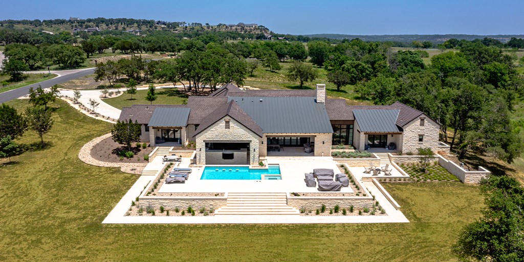 811 Boot Ranch Circle Fredericksburg, TX 78624 - Photo 30 of 34 a view of a house with pool and trees in the background