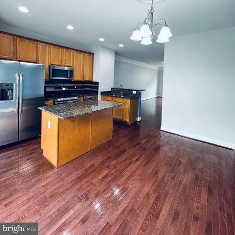 a kitchen with stainless steel appliances granite countertop wooden floors and granite counter tops