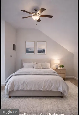 a bedroom with a bed ceiling fan and a window