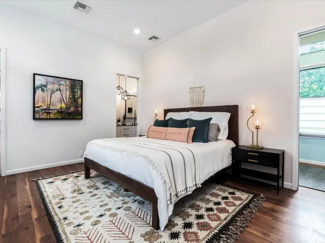 a bedroom with bed and wooden floor