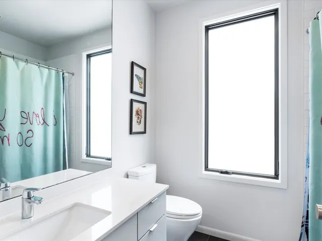 a bathroom with a sink a toilet and a window