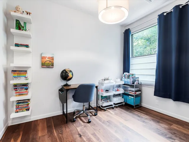 a view of a workspace with furniture and a window