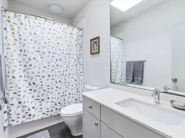 a bathroom with a sink a toilet and a shower curtain