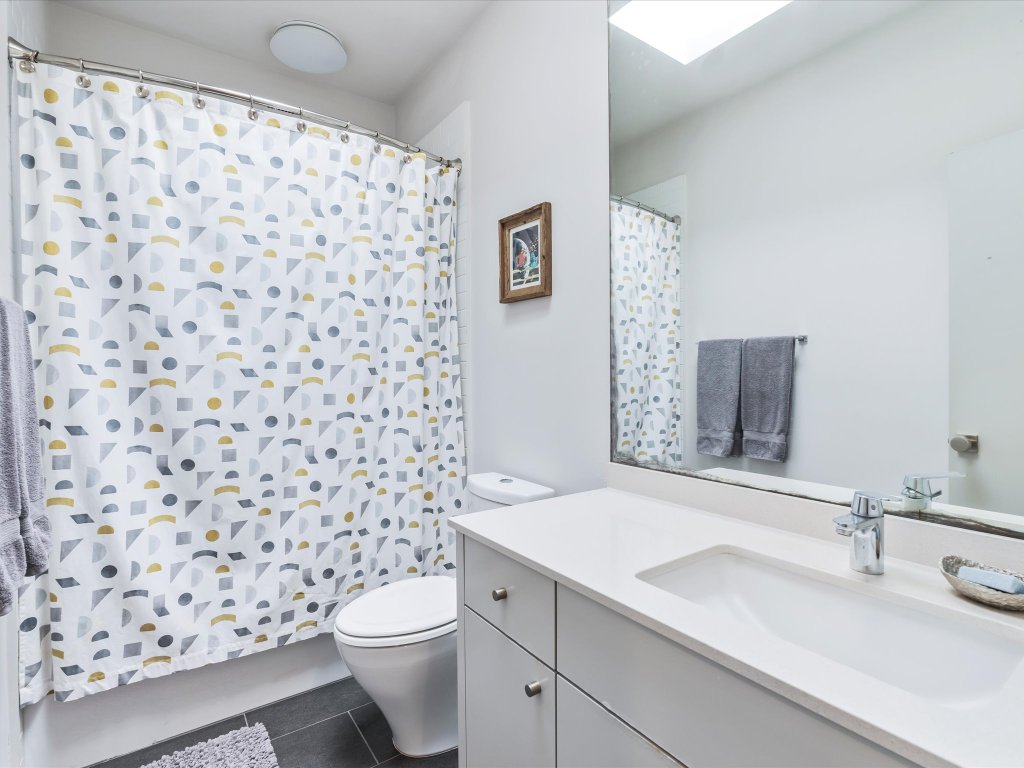 1703 Dexter Street Austin, TX 78704 - Photo 37 of 38 a bathroom with a sink a toilet and a shower curtain