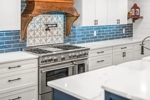 a large kitchen with stainless steel appliances granite countertop a stove and a sink
