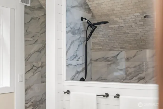 a bathroom with a double vanity sink and mirror with wooden floor