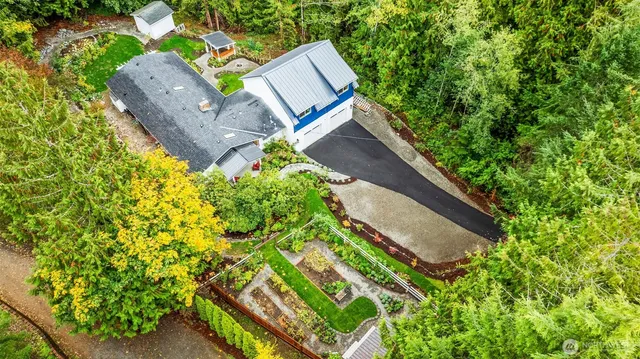 an aerial view of a house with garden space and a patio